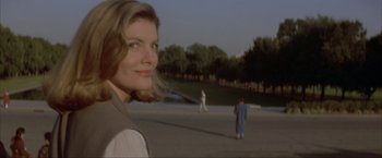 Movie still from “In the Line of Fire” (1993), directed by Wolfgang Petersen – A woman standing in front of two men on a baseball field; Close Up shot, Over the shoulder angle