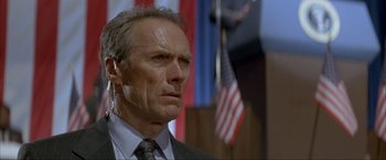 Movie still from “In the Line of Fire” (1993), directed by Wolfgang Petersen – A person wearing a suit and tie; Close Up shot, Low angle