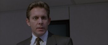 Movie still from “In the Line of Fire” (1993), directed by Wolfgang Petersen – A person wearing a suit and tie; Close Up shot, Low angle