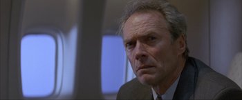 Movie still from “In the Line of Fire” (1993), directed by Wolfgang Petersen – An older man in a suit and tie looking at the camera; Close Up shot, Low angle