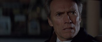Movie still from “In the Line of Fire” (1993), directed by Wolfgang Petersen – A man's face in a suit and tie; Close Up shot, Over the shoulder angle