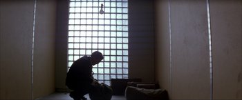Movie still from “In the Line of Fire” (1993), directed by Wolfgang Petersen – A man kneeling down in front of a window; Wide shot, Low angle