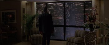 Movie still from “In the Line of Fire” (1993), directed by Wolfgang Petersen – A man standing in front of a window looking at a city at night; Wide shot, Over the shoulder angle