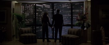 Movie still from “In the Line of Fire” (1993), directed by Wolfgang Petersen – A man and a woman standing in front of a window; Wide shot, Low angle