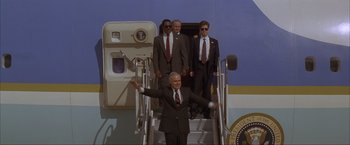Movie still from “In the Line of Fire” (1993), directed by Wolfgang Petersen – A group of men standing on the stairs of an air force one; Wide shot, Low angle