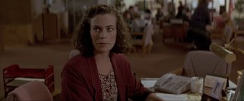 Movie still from “In the Line of Fire” (1993), directed by Wolfgang Petersen – A woman sitting at a table in front of a phone; Close Up shot, Over the shoulder angle