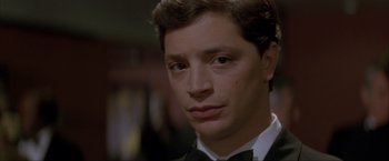 Movie still from “In the Line of Fire” (1993), directed by Wolfgang Petersen – A person wearing a suit and bow tie; Close Up shot, Low angle