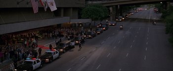 Movie still from “In the Line of Fire” (1993), directed by Wolfgang Petersen – A line of police cars driving down a street; Extreme Wide shot, High angle