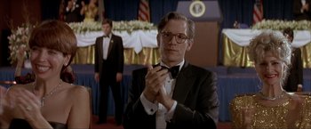 Movie still from “In the Line of Fire” (1993), directed by Wolfgang Petersen – A man in a suit and bow tie holding a tie; Close Up shot, Low angle