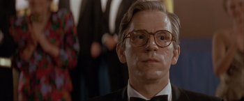 Movie still from “In the Line of Fire” (1993), directed by Wolfgang Petersen – A person wearing a suit and glasses; Close Up shot, Low angle