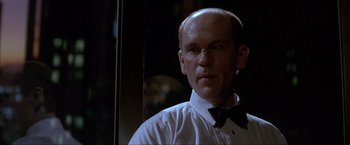 Movie still from “In the Line of Fire” (1993), directed by Wolfgang Petersen – A man in a white shirt and a black bow tie; Close Up shot, Low angle