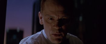 Movie still from “In the Line of Fire” (1993), directed by Wolfgang Petersen – A man's face in a dark room; Close Up shot, Low angle