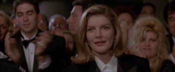 Movie still from “In the Line of Fire” (1993), directed by Wolfgang Petersen – A person wearing a suit and tie; Close Up shot, Over the shoulder angle