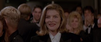 Movie still from “In the Line of Fire” (1993), directed by Wolfgang Petersen – A person wearing a suit and smiling; Close Up shot, Over the shoulder angle