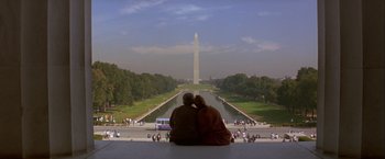 Movie still from “In the Line of Fire” (1993), directed by Wolfgang Petersen – Two people sitting on a ledge looking at the washington monument; Wide shot, Low angle