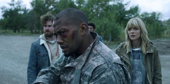 Movie still from “Black Summer” (2019), created by John Hyams – A man in a fatigues with a black eye; Close Up shot, Over the shoulder angle
