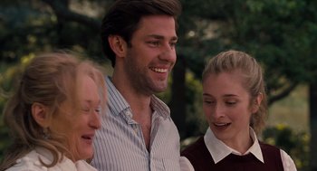 Movie still from “It's Complicated” (2009), directed by Nancy Meyers – A man and two women standing next to each other in front of trees; Close Up shot, Over the shoulder angle