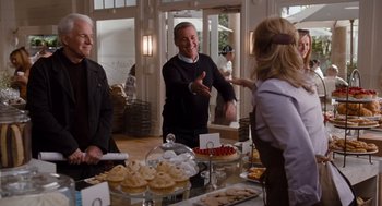 Movie still from “It's Complicated” (2009), directed by Nancy Meyers – A group of people standing in front of a buffet; Medium shot, Over the shoulder angle