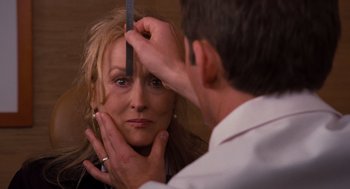 Movie still from “It's Complicated” (2009), directed by Nancy Meyers – A woman looking in a mirror while a man is cutting her hair; Close Up shot, Over the shoulder angle
