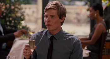 Movie still from “It's Complicated” (2009), directed by Nancy Meyers – A young man holding a glass of champagne; Close Up shot, Over the shoulder angle