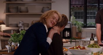 Movie still from “It's Complicated” (2009), directed by Nancy Meyers – A woman hugging a man while sitting at a dinner table; Medium shot, Over the shoulder angle
