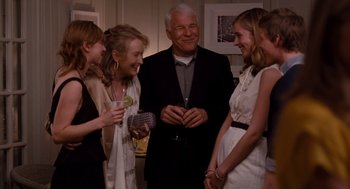 Movie still from “It's Complicated” (2009), directed by Nancy Meyers – A group of people standing next to each other at an event; Medium shot, Over the shoulder angle