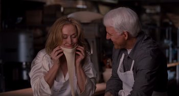 Movie still from “It's Complicated” (2009), directed by Nancy Meyers – An older man and a younger woman in aprons looking at each other; Close Up shot, Over the shoulder angle