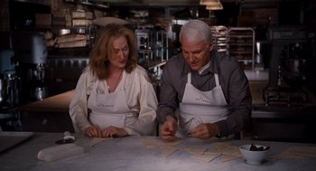 Movie still from “It's Complicated” (2009), directed by Nancy Meyers – A man and a woman working in a kitchen; Medium shot, Over the shoulder angle