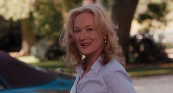 Movie still from “It's Complicated” (2009), directed by Nancy Meyers – A person wearing a shirt smiling; Close Up shot, Over the shoulder angle