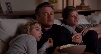 Movie still from “It's Complicated” (2009), directed by Nancy Meyers – A man and two young boys sitting on a couch watching a movie; Medium shot, Over the shoulder angle