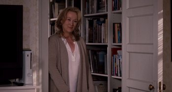 Movie still from “It's Complicated” (2009), directed by Nancy Meyers – A woman standing in front of bookshelves in a room; Medium shot, Over the shoulder angle