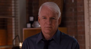 Movie still from “It's Complicated” (2009), directed by Nancy Meyers – An older man with white hair wearing a blue shirt and a black tie; Close Up shot, Over the shoulder angle