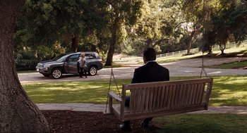 Movie still from “It's Complicated” (2009), directed by Nancy Meyers – A man sitting on top of a wooden park bench; Wide shot, High angle