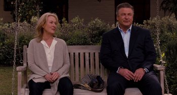 Movie still from “It's Complicated” (2009), directed by Nancy Meyers – A man and a woman sitting on top of a wooden bench; Medium shot, Over the shoulder angle