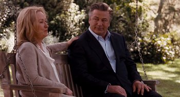 Movie still from “It's Complicated” (2009), directed by Nancy Meyers – An older man sitting on top of a wooden bench next to a woman; Medium shot, Over the shoulder angle