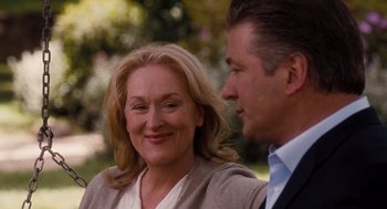 Movie still from “It's Complicated” (2009), directed by Nancy Meyers – A man and a woman smiling for the camera; Close Up shot, Over the shoulder angle