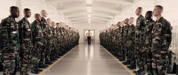 Movie still from “Jarhead” (2005), directed by Sam Mendes – A man standing in front of a group of soldiers; Extreme Wide shot, High angle