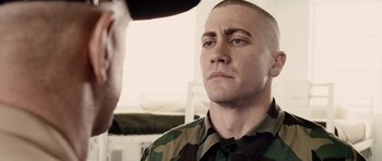 Movie still from “Jarhead” (2005), directed by Sam Mendes – A man in a military uniform looking into the distance; Close Up shot, Over the shoulder angle