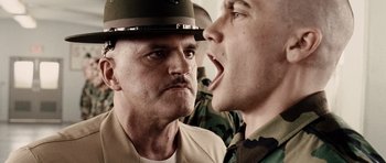 Movie still from “Jarhead” (2005), directed by Sam Mendes – A man in a hat is yelling at another man in a uniform; Close Up shot, Low angle