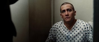 Movie still from “Jarhead” (2005), directed by Sam Mendes – A man in a polka dot shirt sitting in front of a wall; Close Up shot, Low angle