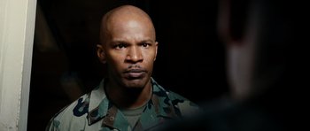 Movie still from “Jarhead” (2005), directed by Sam Mendes – A man in a military uniform is looking at the camera; Close Up shot, Over the shoulder angle