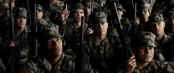Movie still from “Jarhead” (2005), directed by Sam Mendes – A group of men in military uniforms holding guns; Medium shot, Low angle