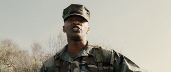 Movie still from “Jarhead” (2005), directed by Sam Mendes – A man in a military uniform is looking at the camera; Close Up shot, Low angle
