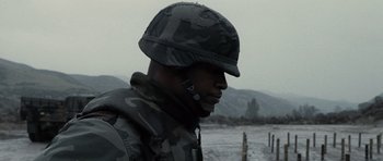Movie still from “Jarhead” (2005), directed by Sam Mendes – A man wearing a camouflage uniform and a helmet; Close Up shot, Low angle