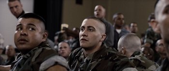 Movie still from “Jarhead” (2005), directed by Sam Mendes – A man with a shaved head is sitting in front of a group of people; Close Up shot, Over the shoulder angle