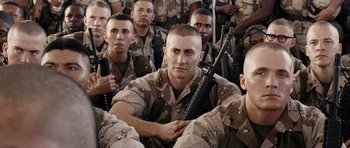 Movie still from “Jarhead” (2005), directed by Sam Mendes – A group of men in camouflage uniforms holding guns; Medium shot, Over the shoulder angle