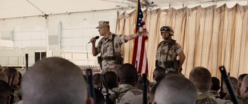 Movie still from “Jarhead” (2005), directed by Sam Mendes – Two men in military fatigues are speaking to a crowd; Medium shot, Over the shoulder angle