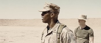 Movie still from “Jarhead” (2005), directed by Sam Mendes – A man in a military uniform standing in the desert; Close Up shot, Low angle