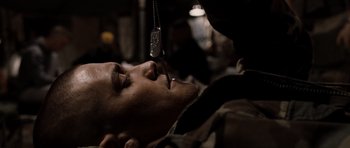 Movie still from “Jarhead” (2005), directed by Sam Mendes – A man laying down with a cell phone hanging above his head; Close Up shot, High angle