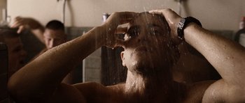 Movie still from “Jarhead” (2005), directed by Sam Mendes – A man is taking a shower in the bathroom; Close Up shot, Low angle